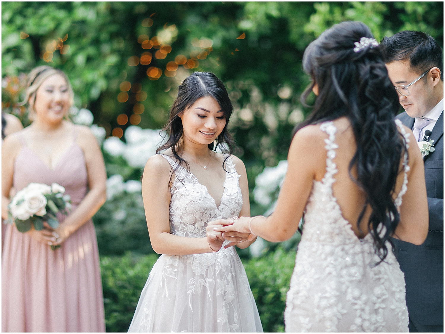 Brides exchanging vows in a lush garden setting at Christmas House Inn.
