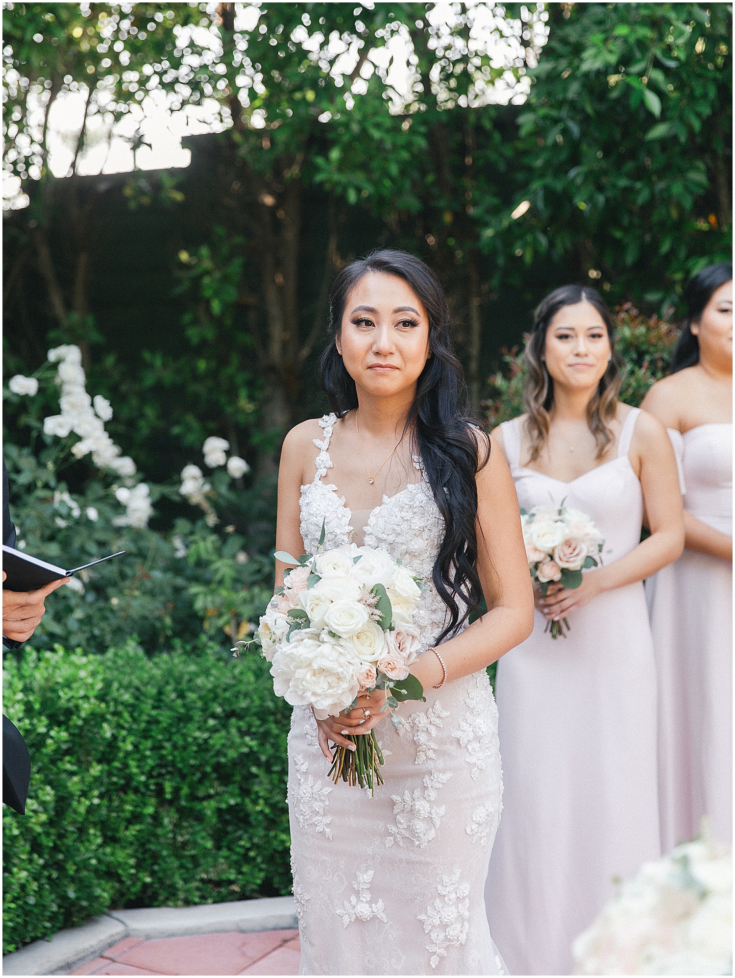 Brides exchanging vows in a lush garden setting at Christmas House Inn.