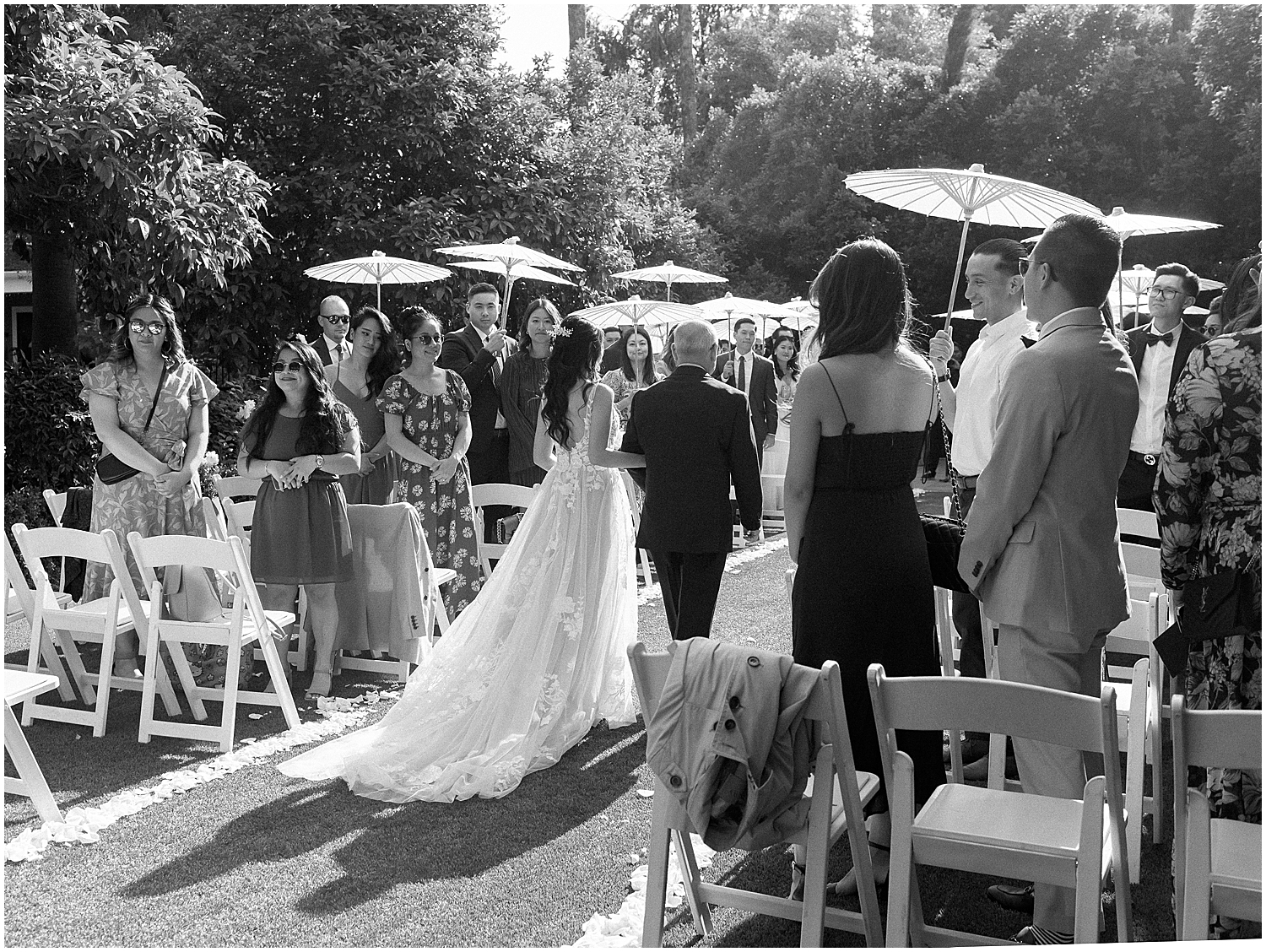 Brides exchanging vows in a lush garden setting at Christmas House Inn.