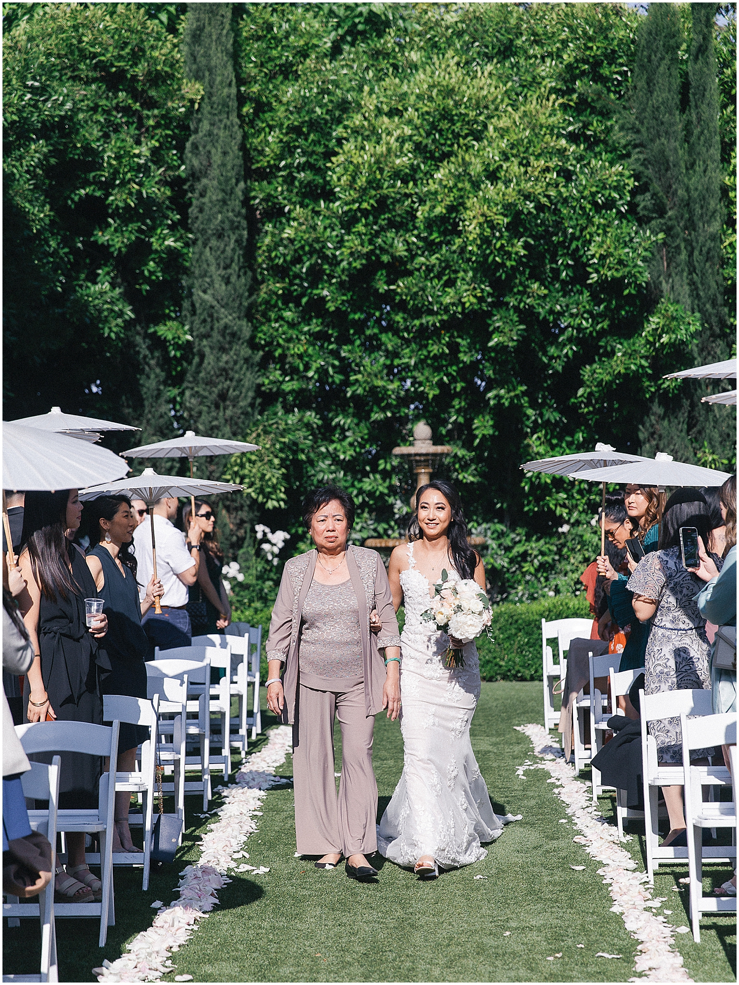 Brides exchanging vows in a lush garden setting at Christmas House Inn.