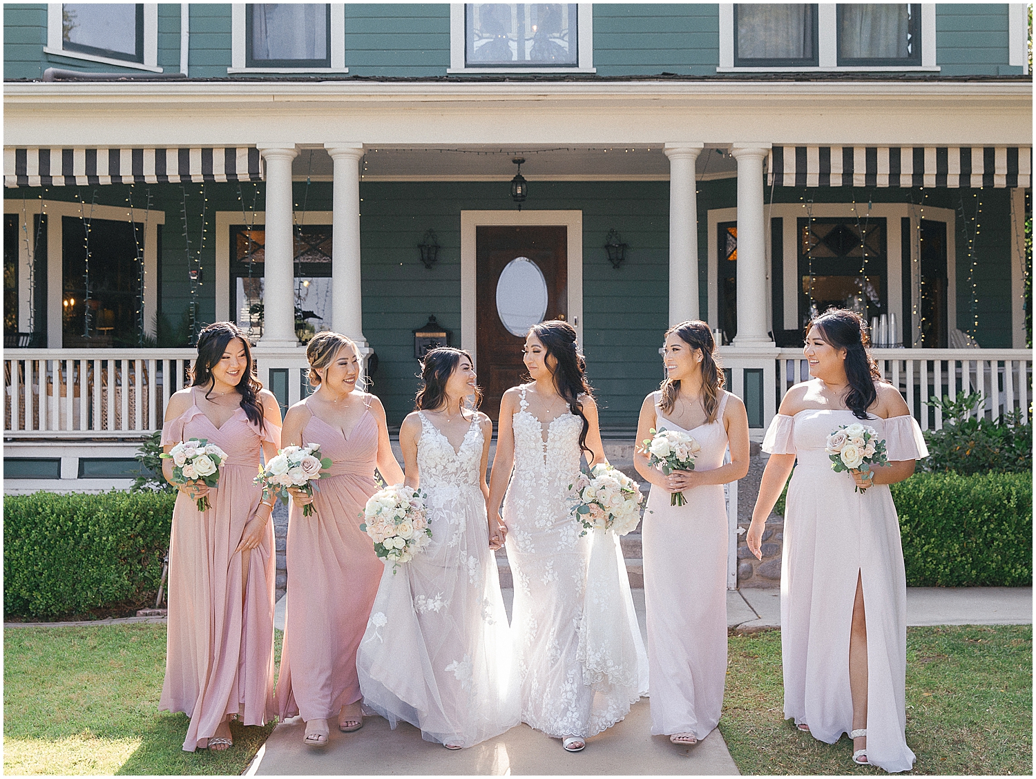 Brides share a joyful moment at their whimsical garden wedding in Southern California.