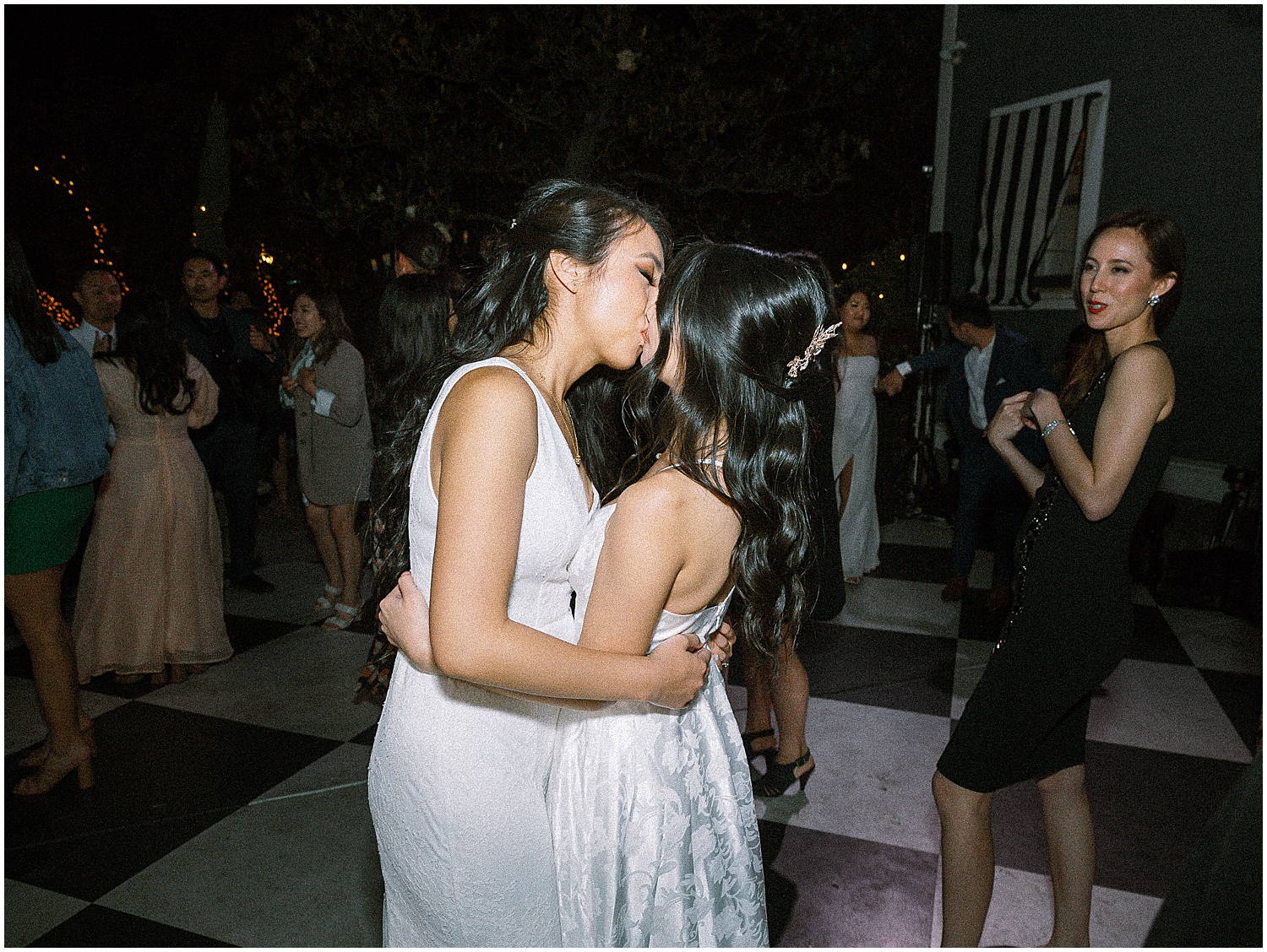 Romantic first dance under twinkling lights at an intimate LGBTQ+ wedding.